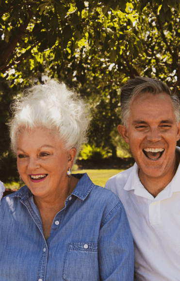Couple laughing together under trees